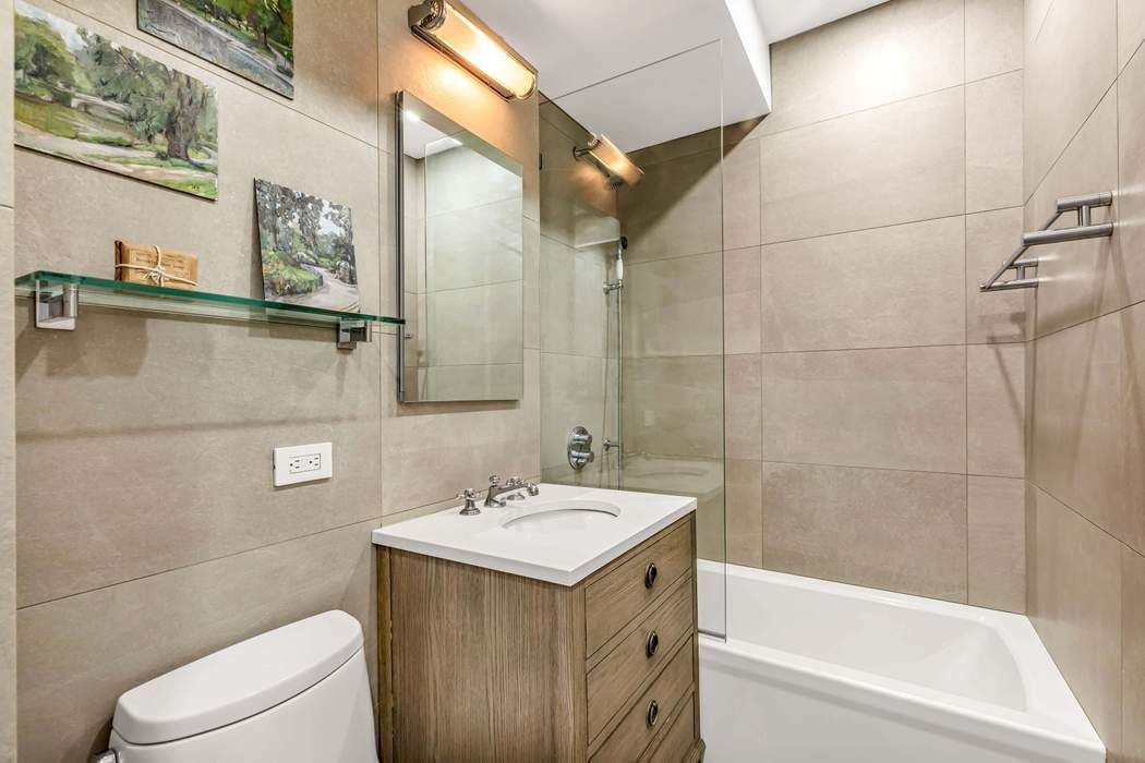 64 East 94th Street, Unit 1G Manhattan, NY 10128 - Photo 7 of 11 a bathroom with a sink a toilet and shower