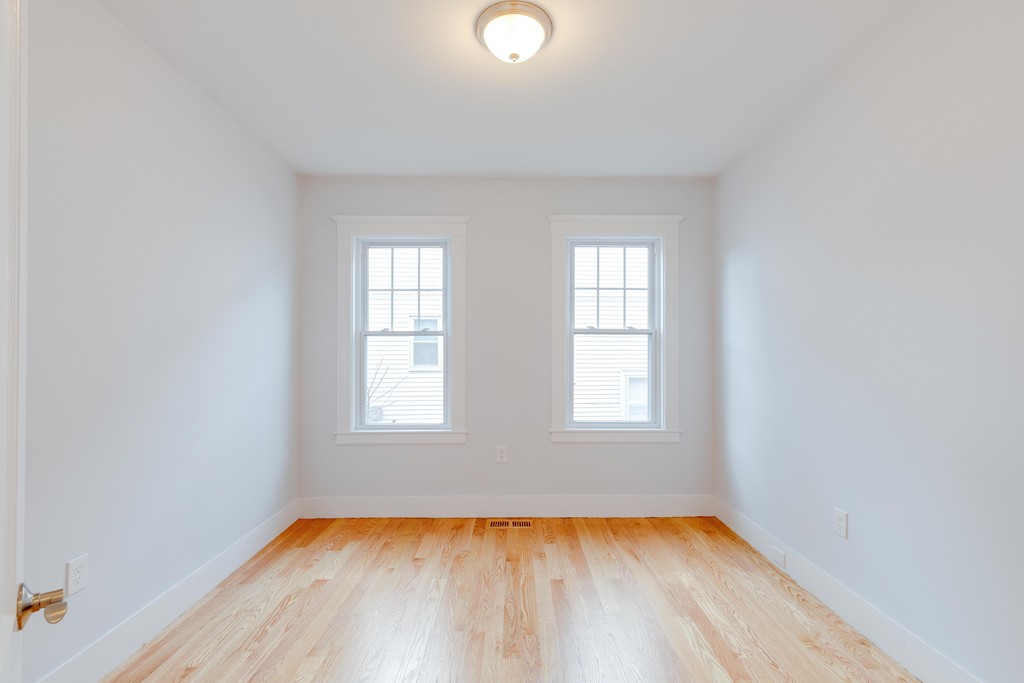 57 Katherine Road, Unit 57 Watertown, MA 02472 - Photo 19 of 30 an empty room with wooden floor and windows