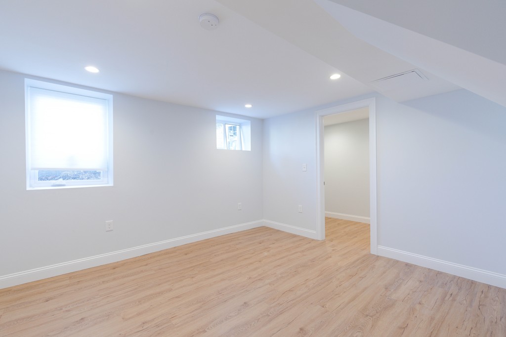 57 Katherine Road, Unit 57 Watertown, MA 02472 - Photo 24 of 30 a view of an empty room with wooden floor and a window