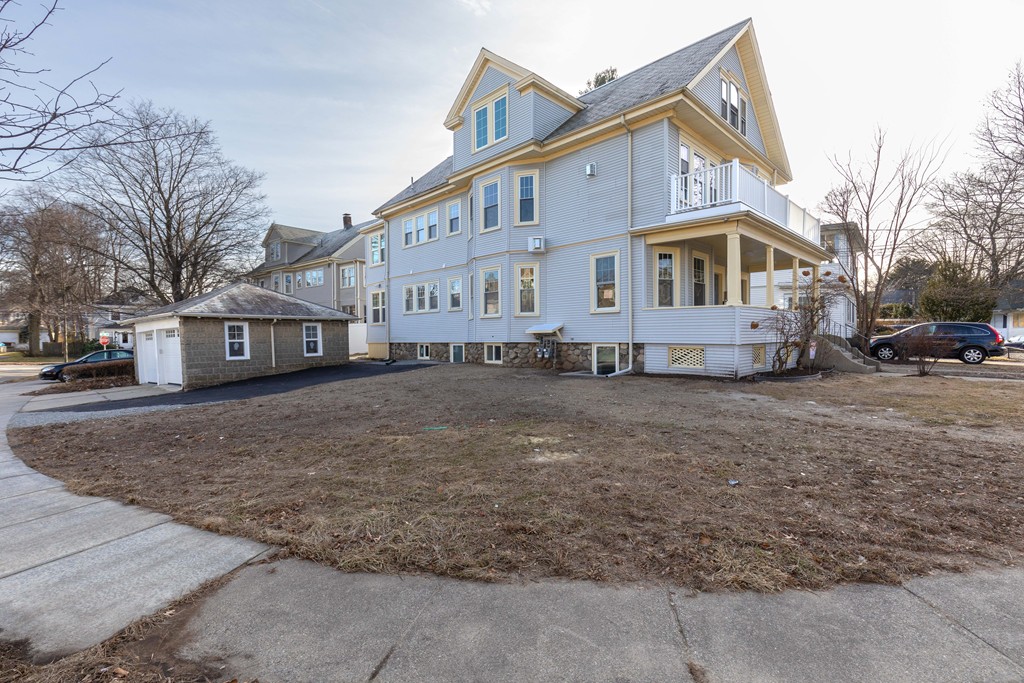 57 Katherine Road, Unit 57 Watertown, MA 02472 - Photo 29 of 30 a view of a white house with large trees next to a road