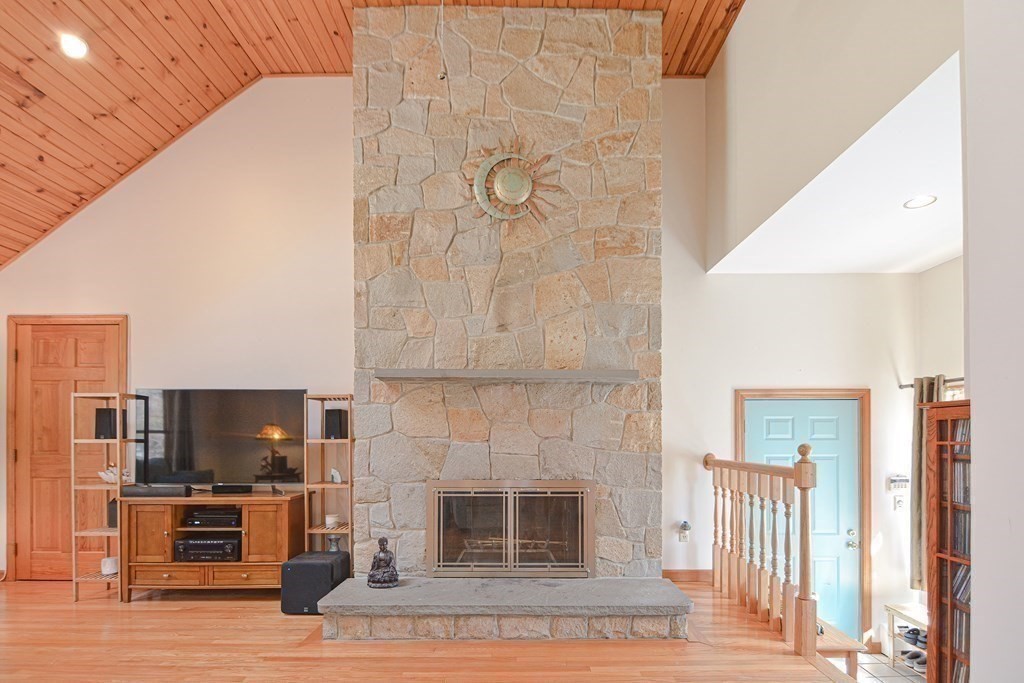 27 Wilson Pond Road Rowley, MA 01969 - Photo 12 of 42 a living room with furniture a fireplace and a flat screen tv