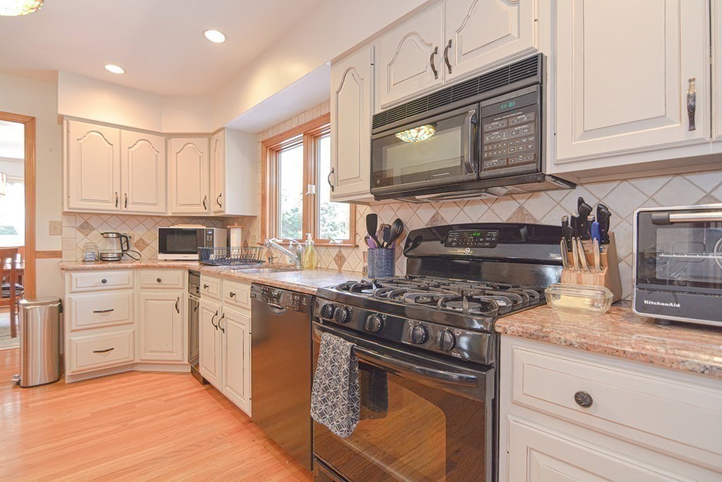 27 Wilson Pond Road Rowley, MA 01969 - Photo 17 of 42 a kitchen with cabinets stainless steel appliances and a sink