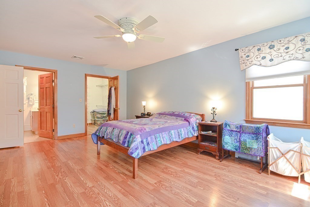 27 Wilson Pond Road Rowley, MA 01969 - Photo 29 of 42 a spacious bedroom with a bed and a chandelier