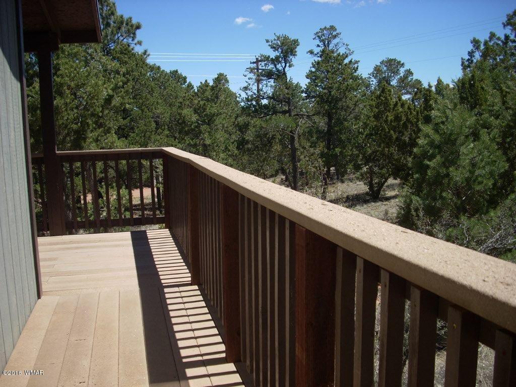 3145 Aspen Road Overgaard, AZ 85933 - Photo 13 of 36 a balcony with wooden floor and yard in the back