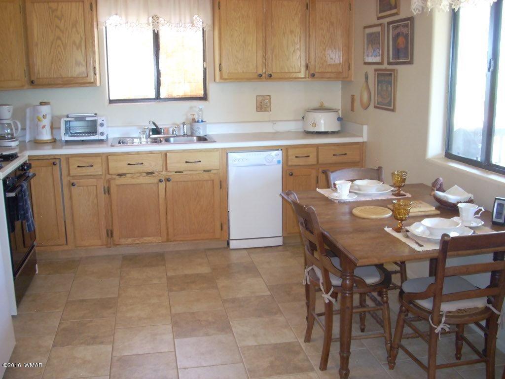 3145 Aspen Road Overgaard, AZ 85933 - Photo 23 of 36 a kitchen with a sink a stove a table and chairs