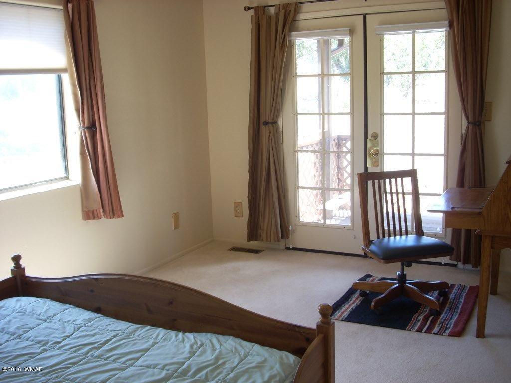 3145 Aspen Road Overgaard, AZ 85933 - Photo 24 of 36 a bedroom with a bed and a window