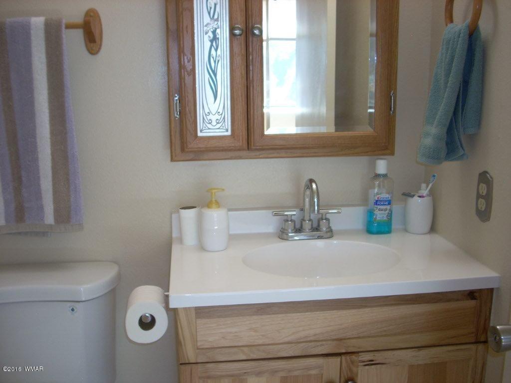 3145 Aspen Road Overgaard, AZ 85933 - Photo 27 of 36 a bathroom with a sink and a mirror