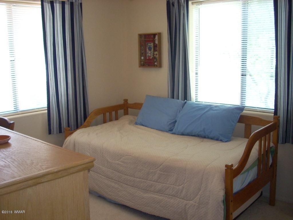 3145 Aspen Road Overgaard, AZ 85933 - Photo 28 of 36 a bedroom with a bed and a window