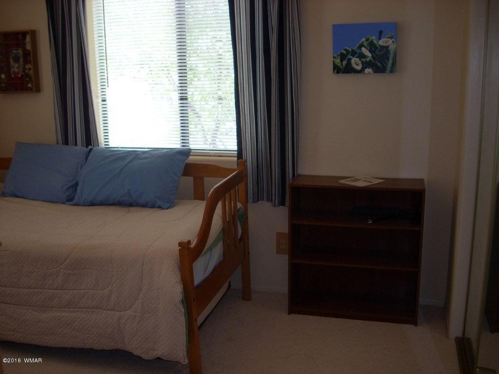 3145 Aspen Road Overgaard, AZ 85933 - Photo 29 of 36 a bedroom with a bed and a window