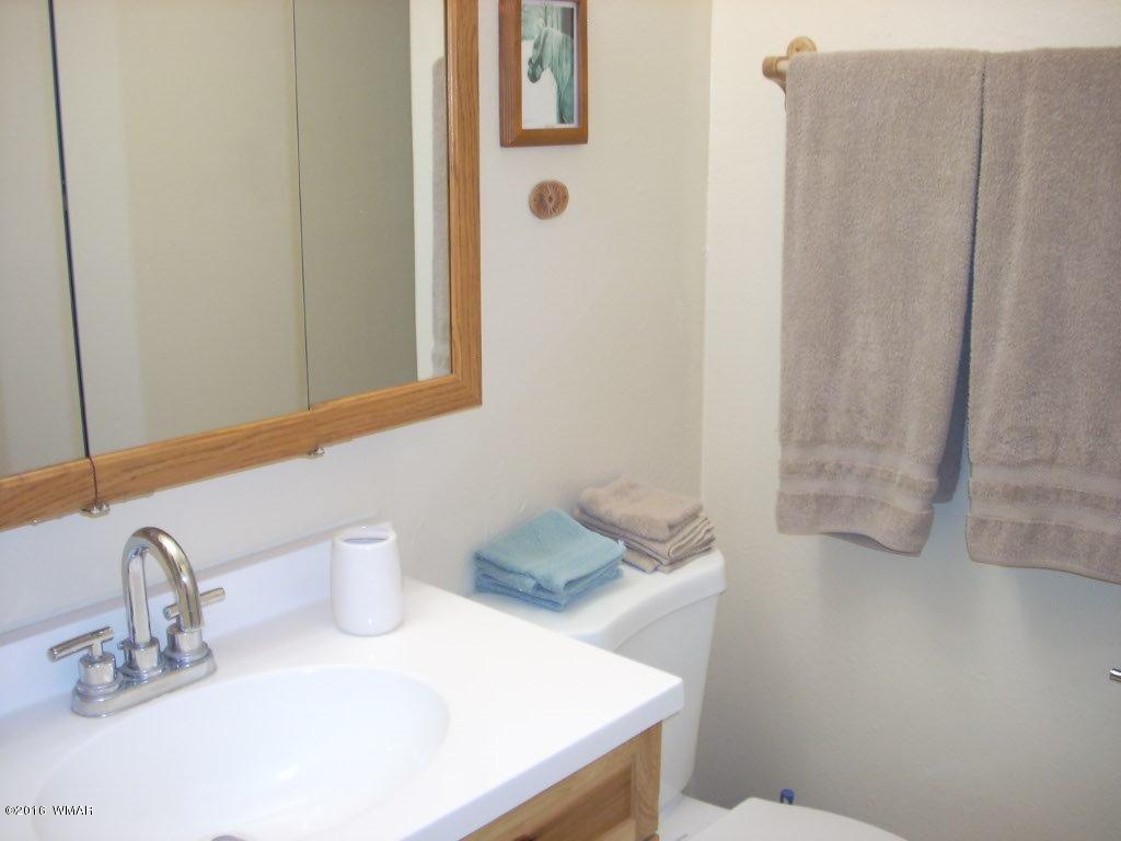 3145 Aspen Road Overgaard, AZ 85933 - Photo 31 of 36 a bathroom with a sink and a mirror