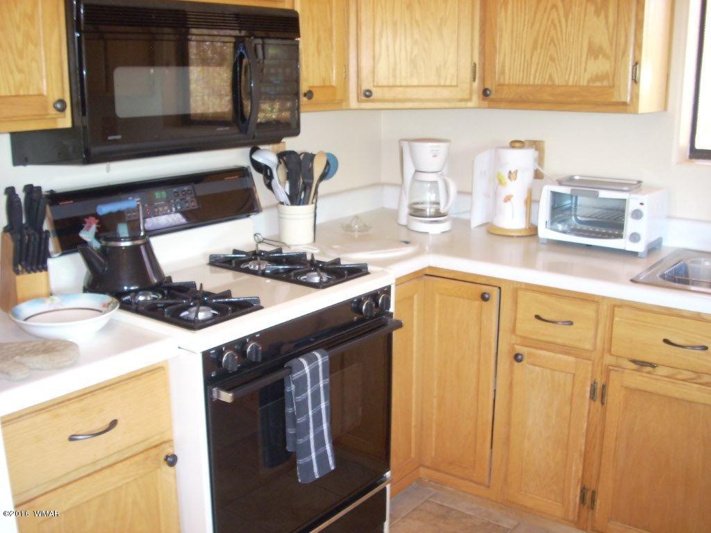 3145 Aspen Road Overgaard, AZ 85933 - Photo 34 of 36 a kitchen with granite countertop a sink stove and cabinets