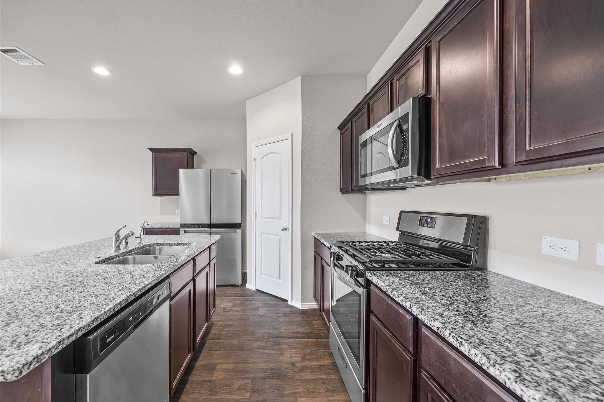 23522 Wedgewood Cliff Way Spring, TX 77373 - Photo 6 of 30 a kitchen with stainless steel appliances granite countertop a sink stove microwave and cabinets