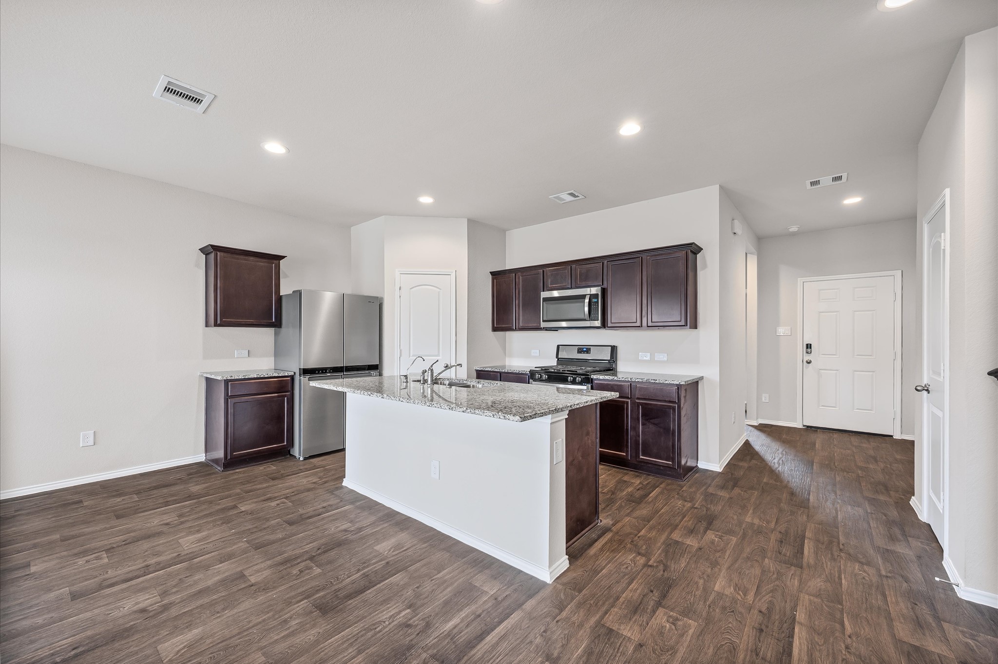 23522 Wedgewood Cliff Way Spring, TX 77373 - Photo 9 of 30 a kitchen with stainless steel appliances kitchen island granite countertop a stove top oven a sink a counter top space and cabinets