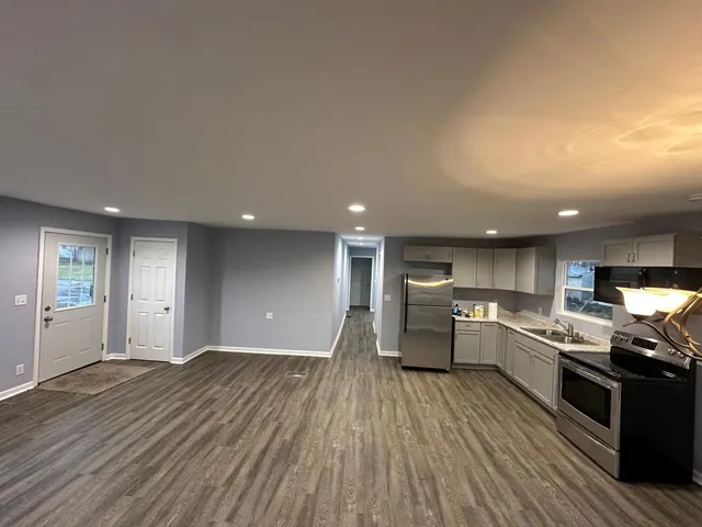 a kitchen with granite countertop a stove top oven and cabinets