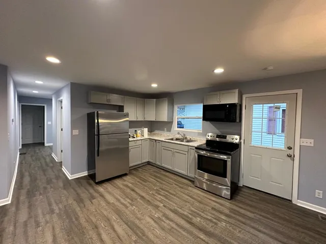 a kitchen with refrigerator a stove a sink and a microwave