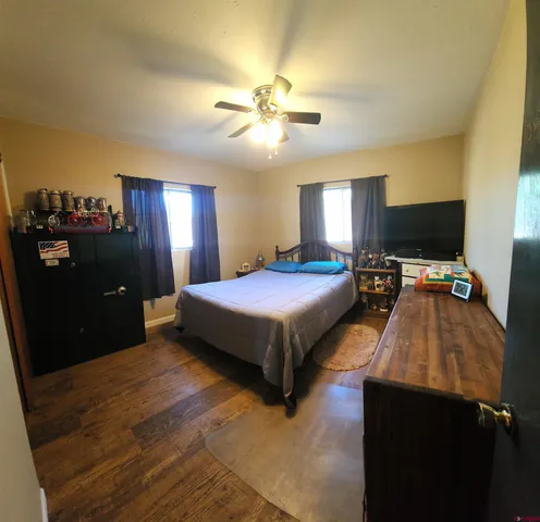 a bedroom with a bed and a flat tv screen on dresser