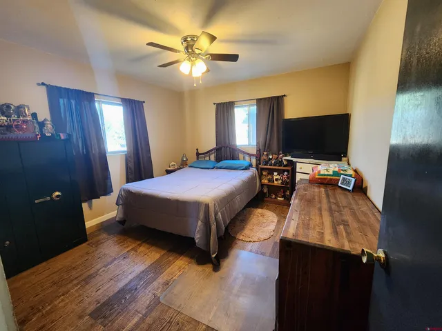 a bedroom with a bed and a flat tv screen on dresser