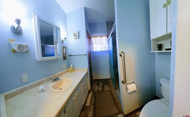 a bathroom with a granite countertop toilet a sink and mirror
