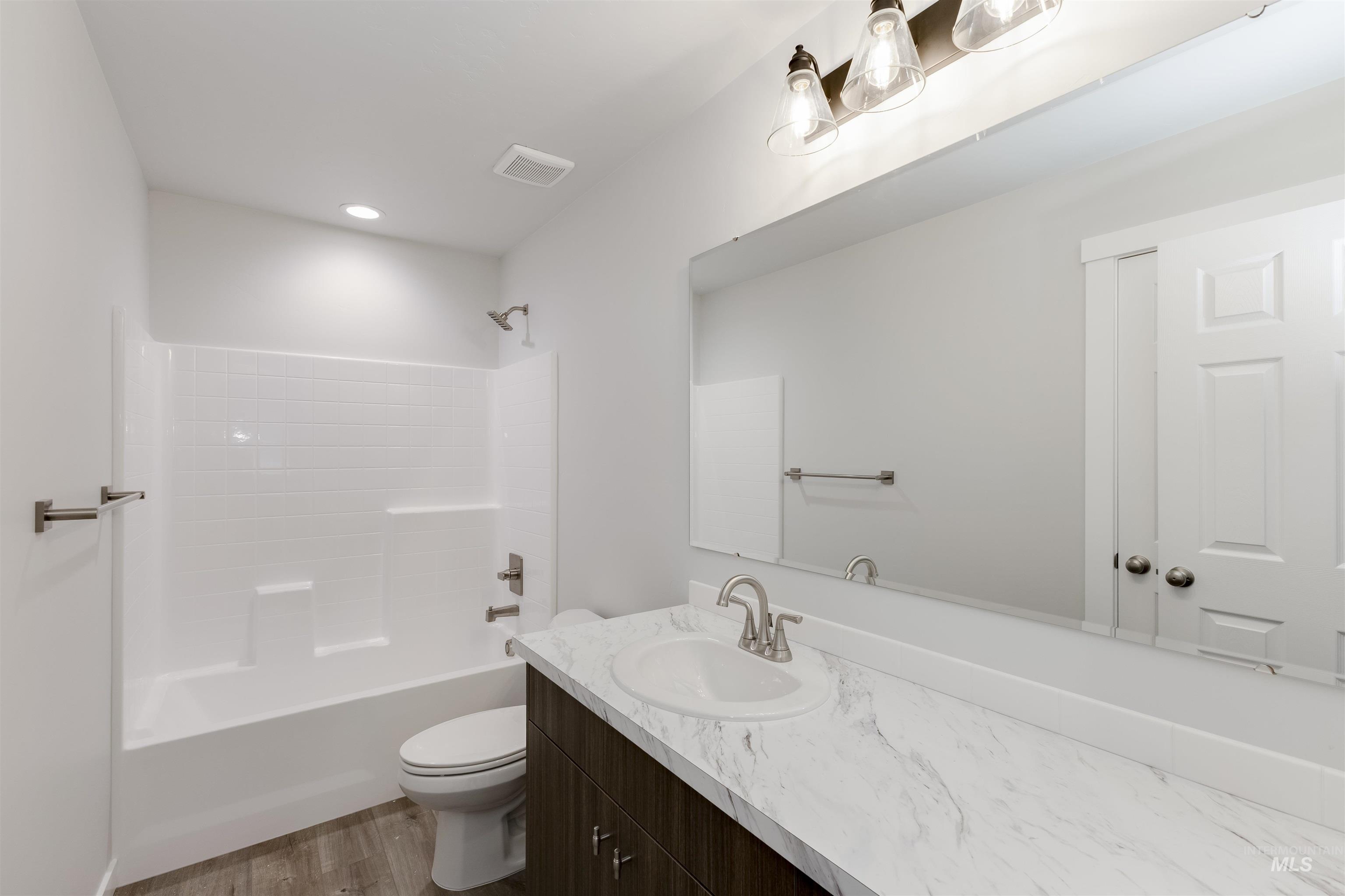 10865 Rutland Street Caldwell, ID 83605 - Photo 12 of 20 Full bath with vanity, bathtub / shower combination, and dark wood-type flooring
