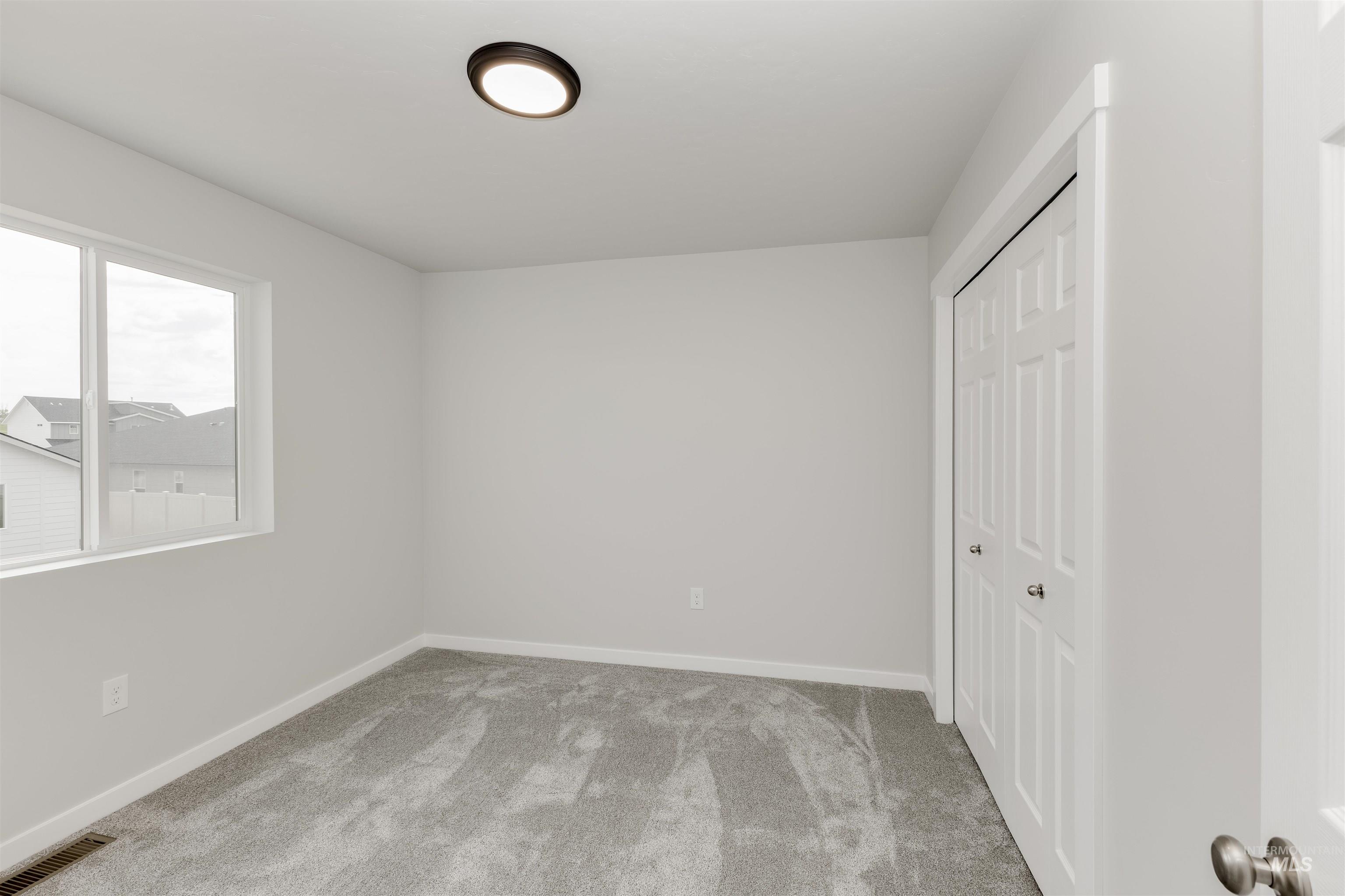 10865 Rutland Street Caldwell, ID 83605 - Photo 14 of 20 Unfurnished bedroom featuring light carpet and a closet