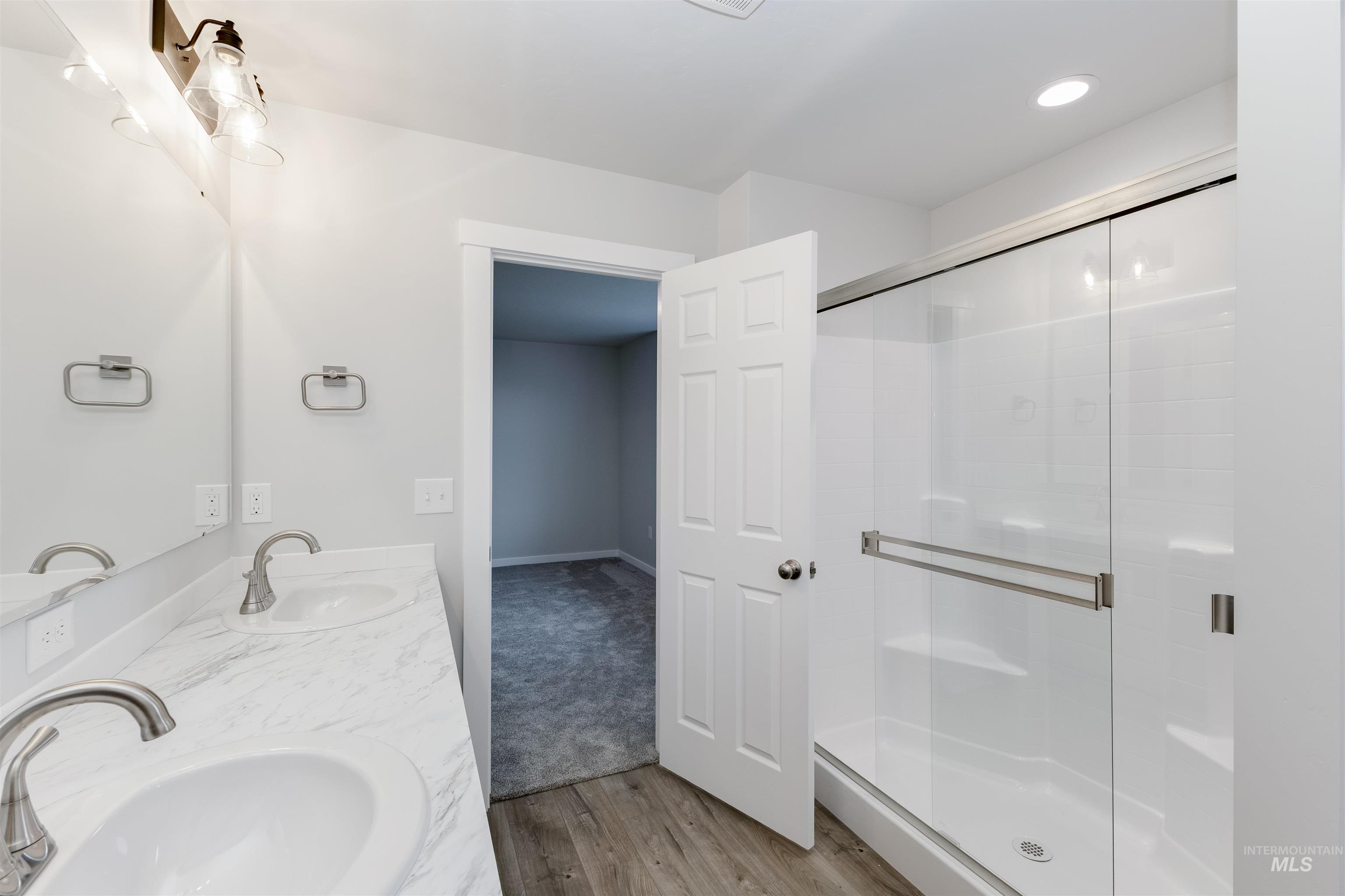 10865 Rutland Street Caldwell, ID 83605 - Photo 18 of 20 Bathroom featuring double vanity, a stall shower, and light wood-style floors