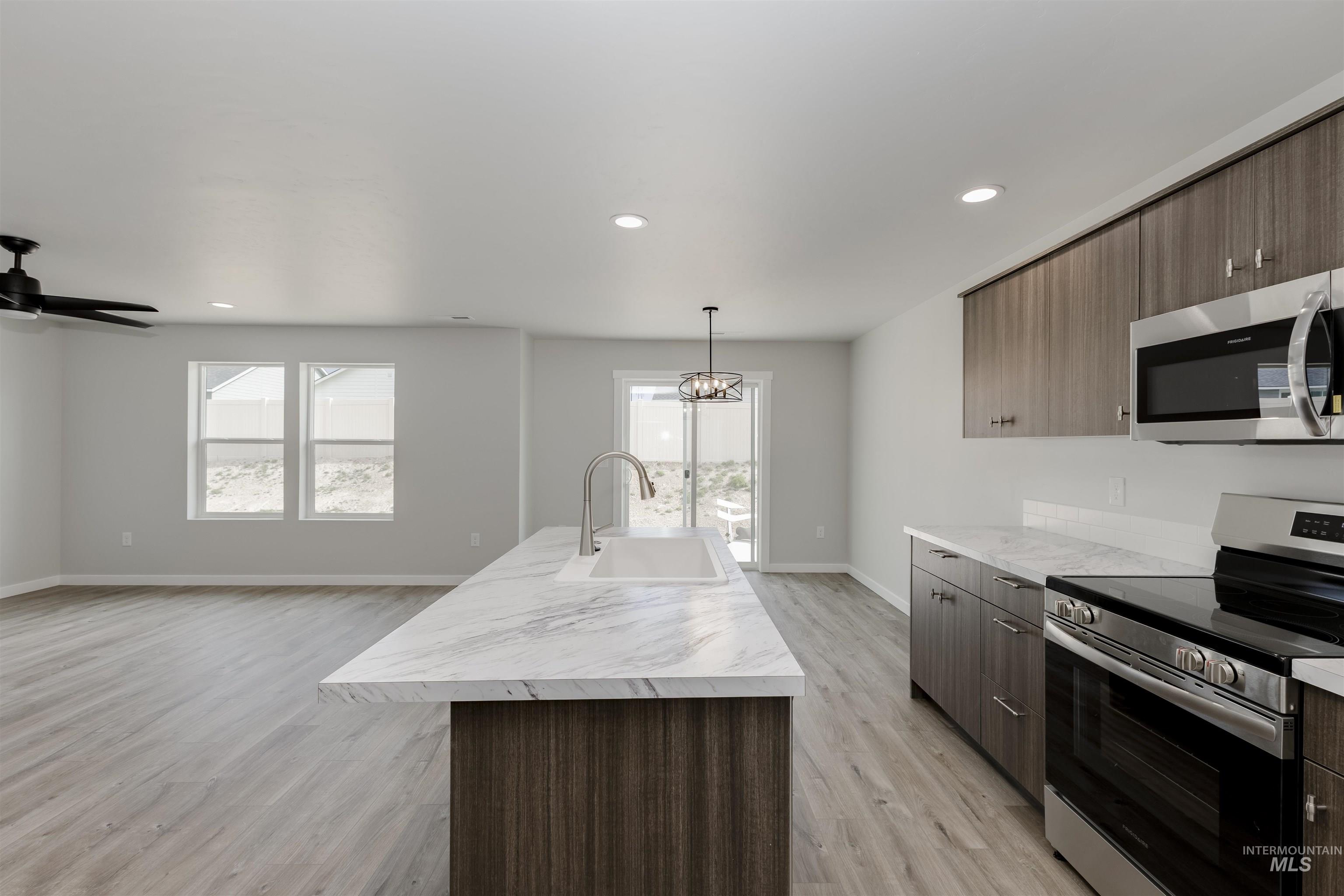 10865 Rutland Street Caldwell, ID 83605 - Photo 5 of 20 Kitchen with appliances with stainless steel finishes, modern cabinets, decorative light fixtures, recessed lighting, and dark brown cabinetry