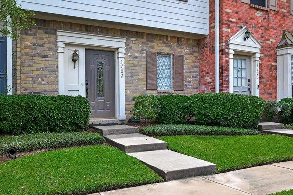 a view of a brick house with a yard