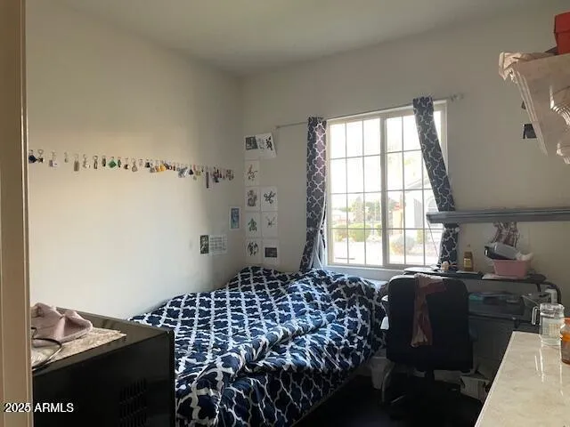 a bedroom with bed window and chair