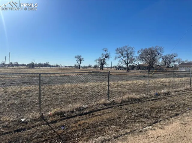 a view of a yard with wooden fence