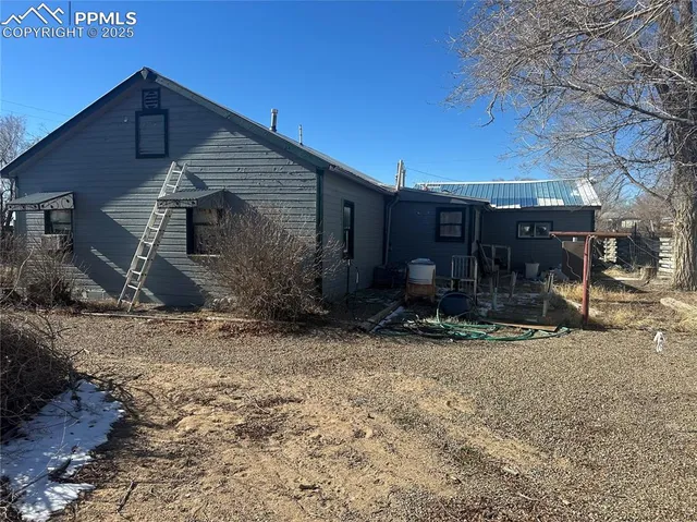 a view of a house with backyard and trees