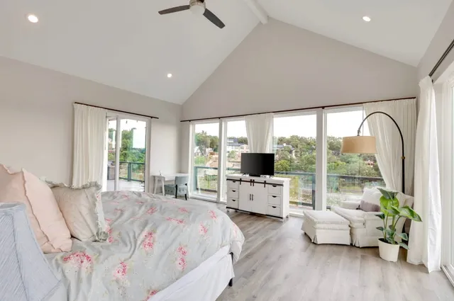 a bedroom with furniture and large windows