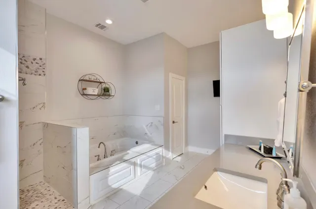 a bathroom with a tub sink and mirror