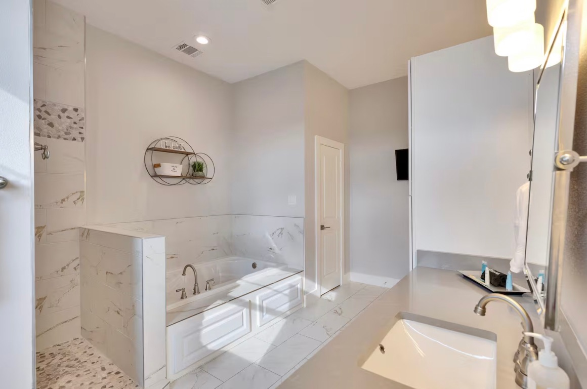 16323 Lake Loop Austin, TX 78734 - Photo 15 of 30 Full bathroom with a bath, tiled shower, vanity, marble look tiles, and recessed lighting