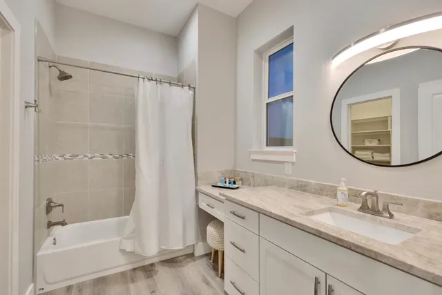 a bathroom with a granite countertop tub sink and mirror
