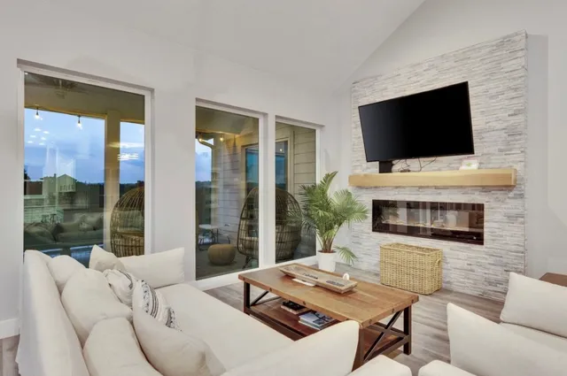 a living room with furniture a flat screen tv and a fireplace