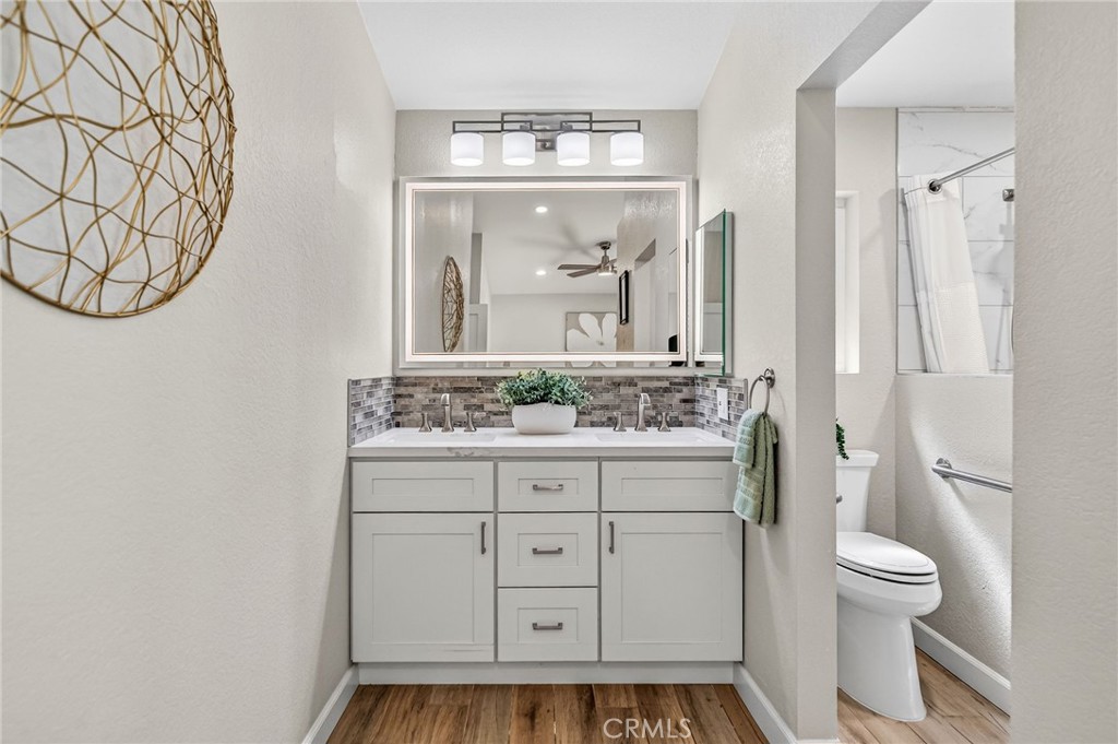 9290 Hot Springs Road Corona, CA 92883 - Photo 16 of 25 a bathroom with a granite countertop sink a toilet and a mirror