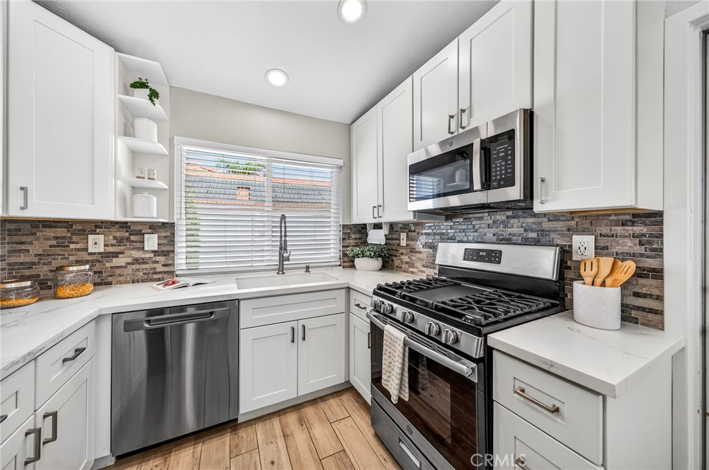 9290 Hot Springs Road Corona, CA 92883 - Photo 6 of 25 a kitchen with stainless steel appliances white cabinets granite counter tops and a window