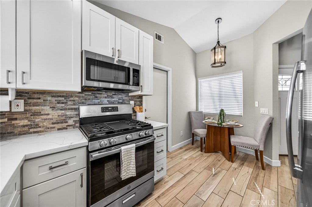 9290 Hot Springs Road Corona, CA 92883 - Photo 7 of 25 a kitchen with stainless steel appliances a stove sink microwave and cabinets