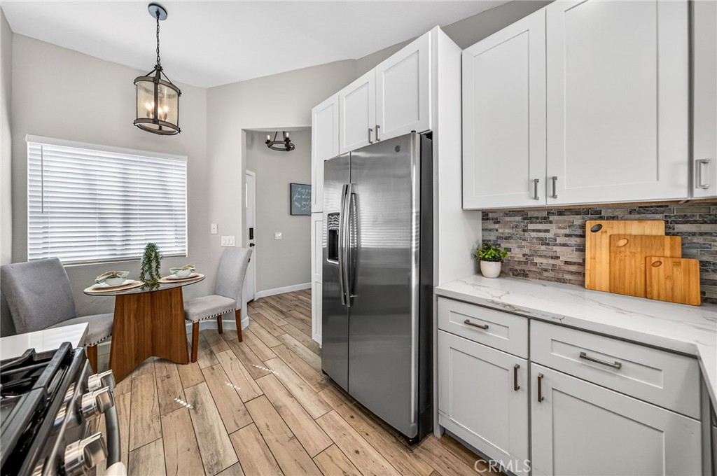 9290 Hot Springs Road Corona, CA 92883 - Photo 8 of 25 a kitchen with stainless steel appliances granite countertop a refrigerator a sink dishwasher a stove and white countertops with wooden floor