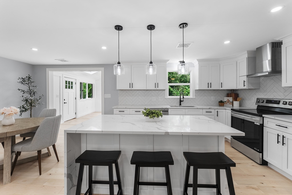 456 Parsonage Street Marshfield, MA 02050 - Photo 4 of 41 a kitchen with stainless steel appliances granite countertop a table chairs sink and cabinets