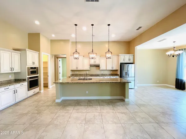 a kitchen with stainless steel appliances granite countertop a sink a oven and a refrigerator