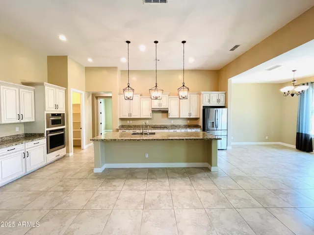 a kitchen with stainless steel appliances granite countertop a sink a oven and a refrigerator