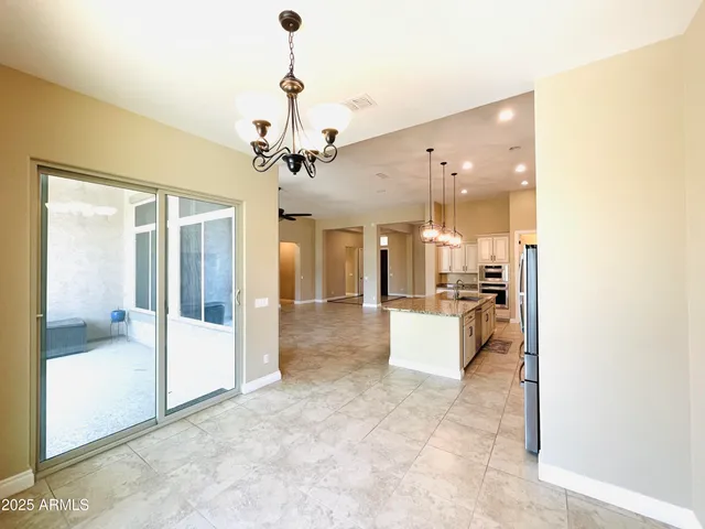 a view of a kitchen with kitchen island granite countertop a sink and a stove