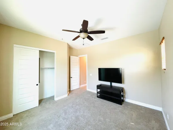 a view of an empty room with kitchen and sink