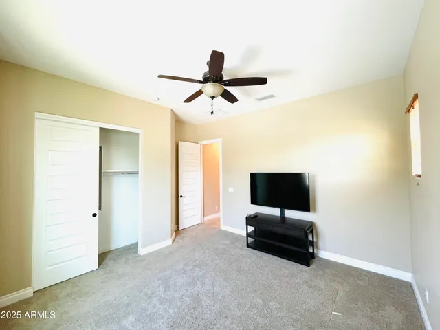 a view of an empty room with kitchen and sink