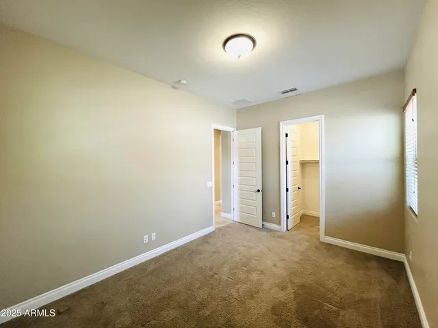 an empty room with ceiling fan and closet area