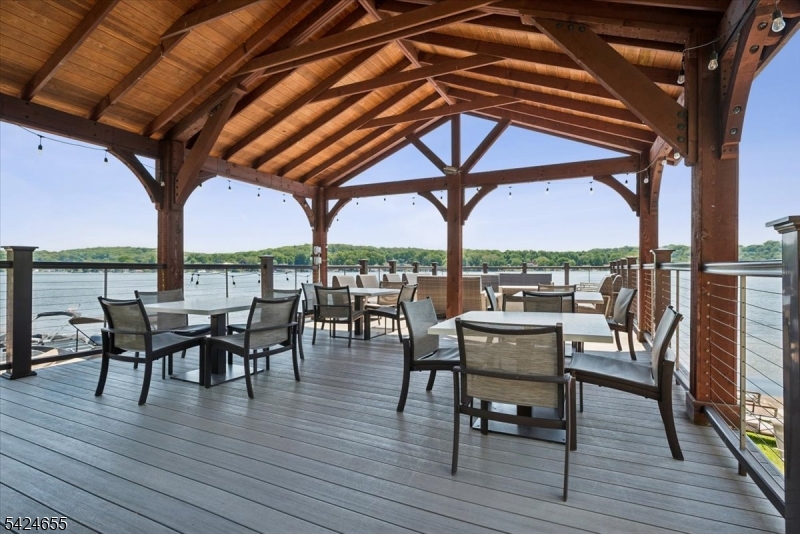 401 Mariners Pointe Hopatcong, NJ 07843 - Photo 3 of 42 a view of a roof deck with table and chairs couches with wooden floor and fence