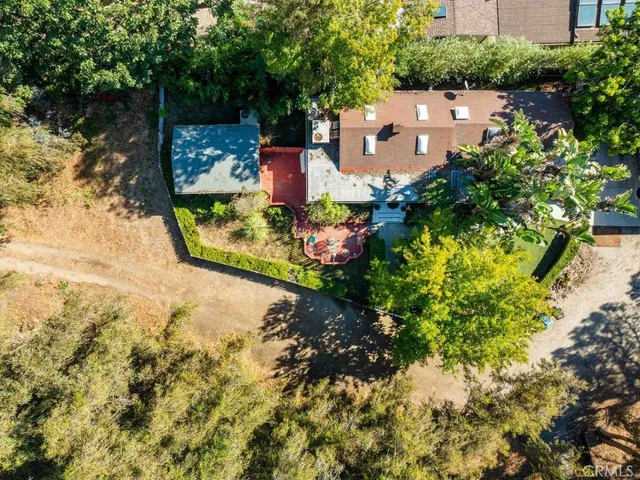 an aerial view of a house with a yard and large trees