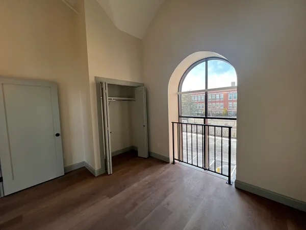 an empty room with wooden floor and a window