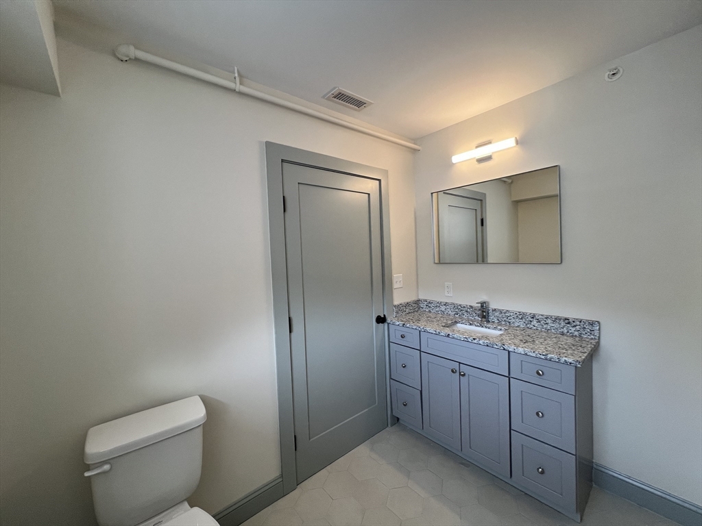 160 Seabury Street, Unit 29 Fall River, MA 02720 - Photo 14 of 17 a spacious bathroom with a toilet a sink a mirror and vanity